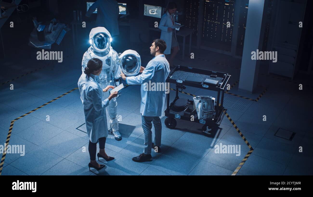 Struttura aerospaziale: Scienziati, ingegneri che indossano camici bianchi  hanno discussione, uso computer, costruire astronauta casco per New Space  Suit adattato Foto stock - Alamy