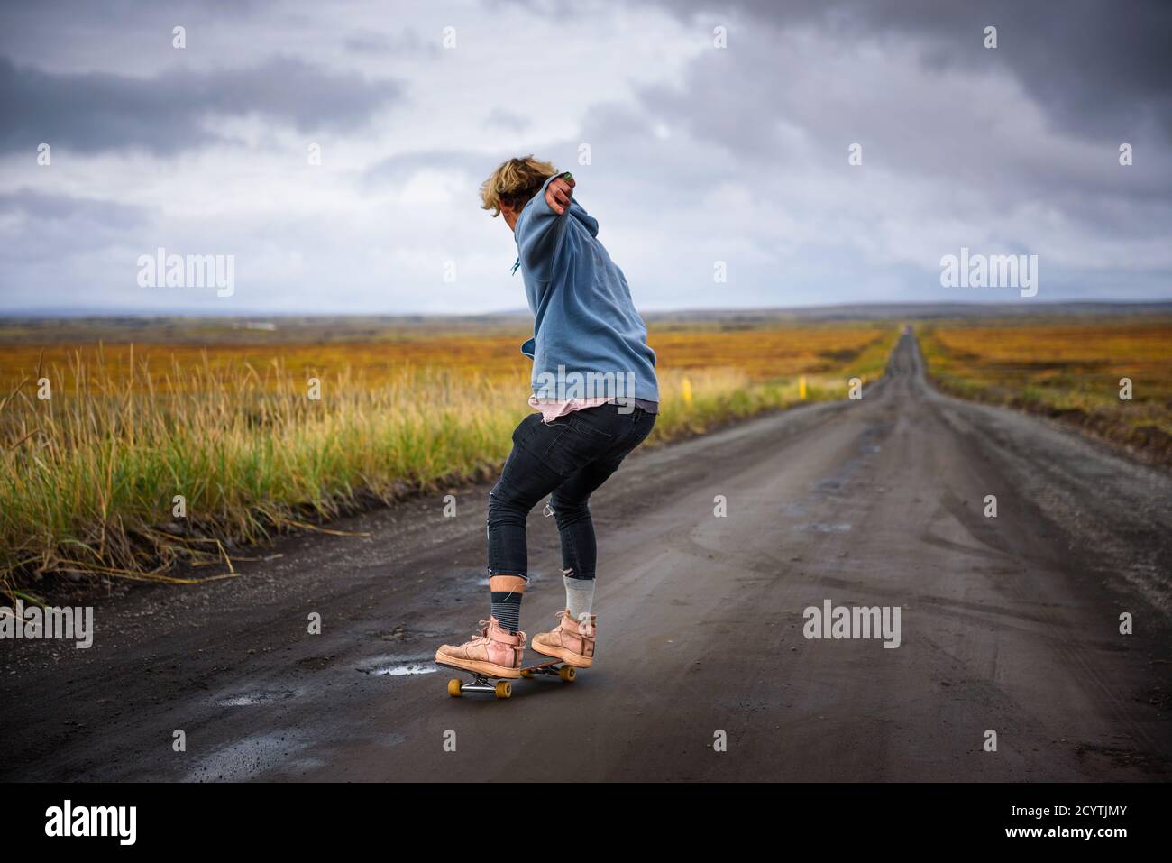 Azione di un pattinatore su una strada sterrata in Islanda Foto Stock