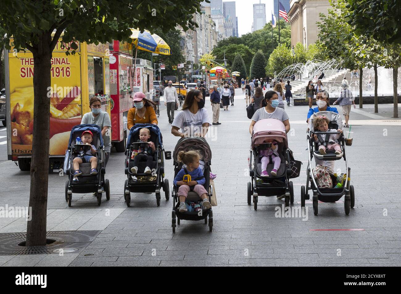 Gruppo di 'nannies' camminano insieme ai bambini piccoli in passeggini passando per IL MUSEO MET sulla 5th Avenue sul lato Upper East a Manhattan, New York City. Foto Stock