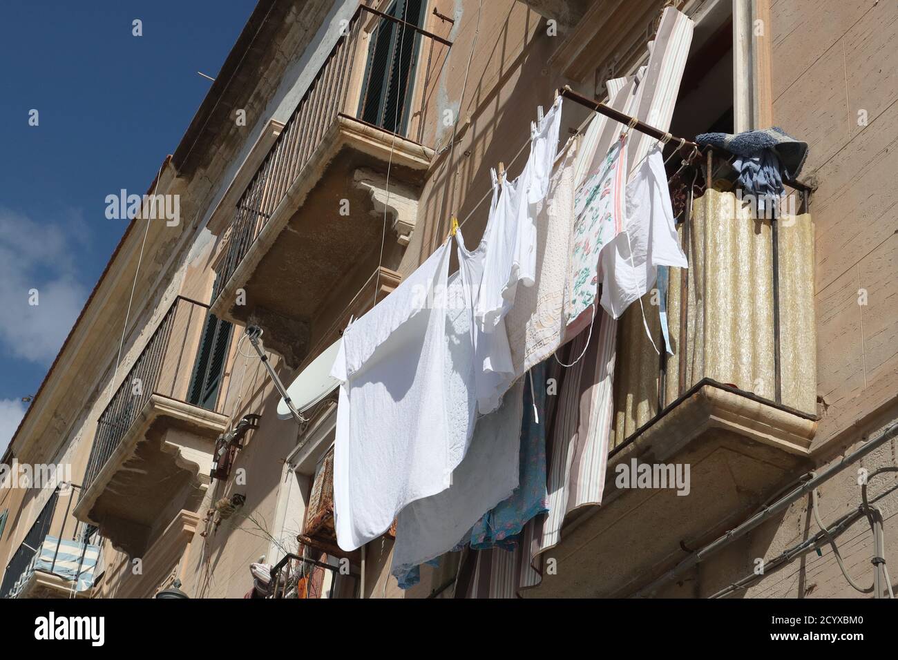 Lavaggio appeso ad asciugare al sole su un balcone nel centro storico di Trapani, in Sicilia Foto Stock