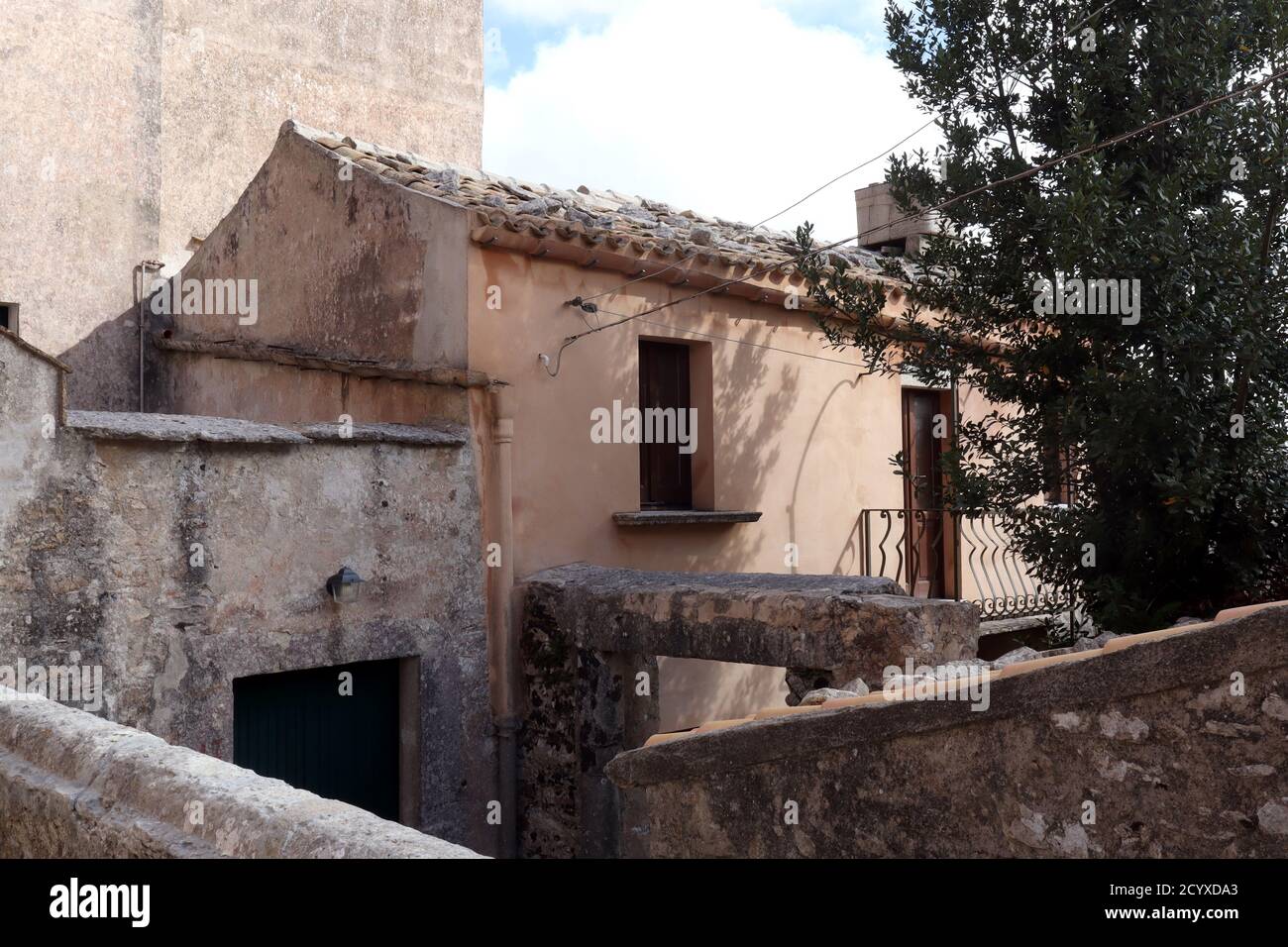 Colorate vecchie case in pietra lungo la stretta strada acciottolata a Erice, in Sicilia Foto Stock