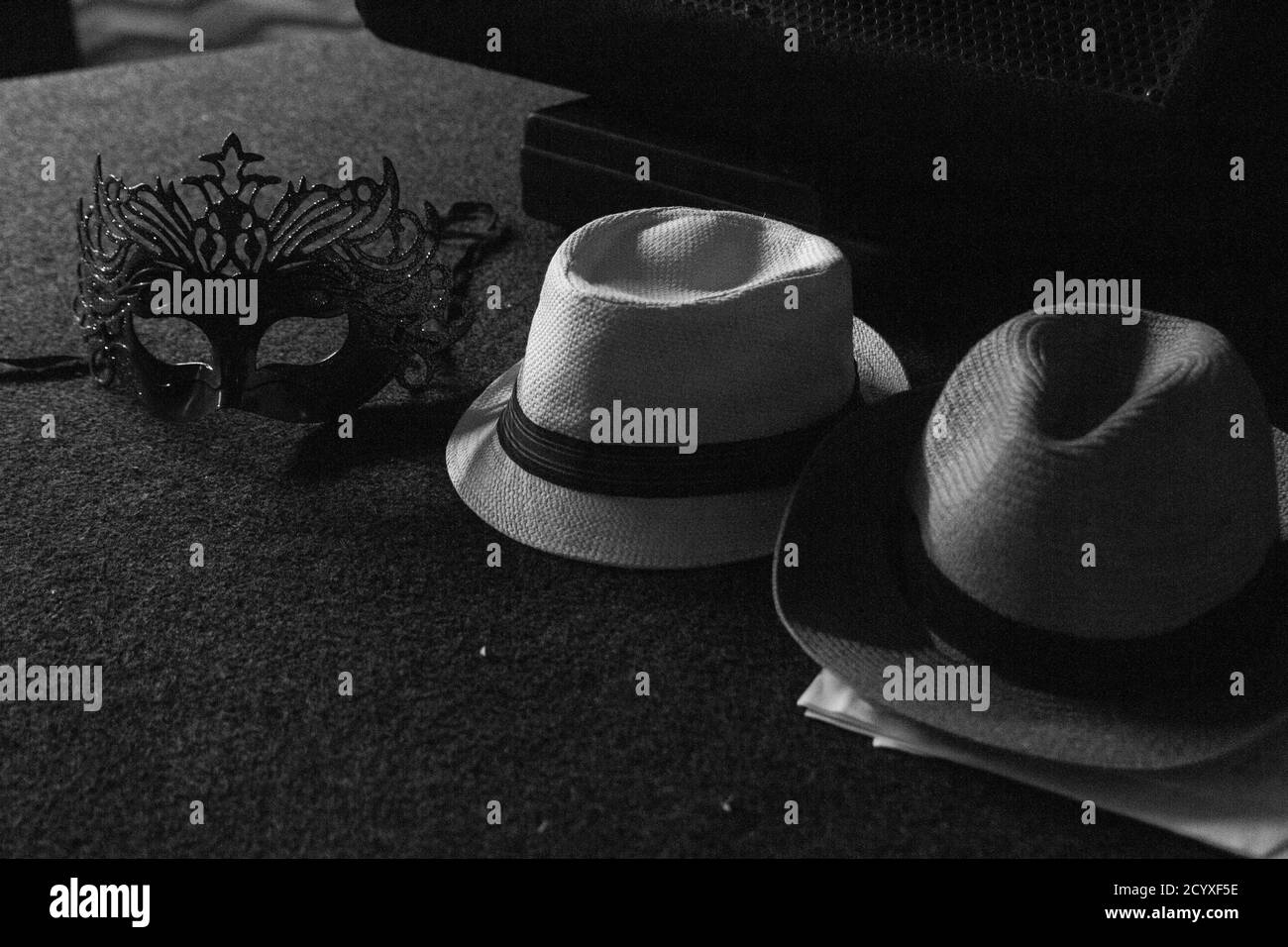 Scala di grigi di maschera carnevale e cappelli di paglia Foto Stock
