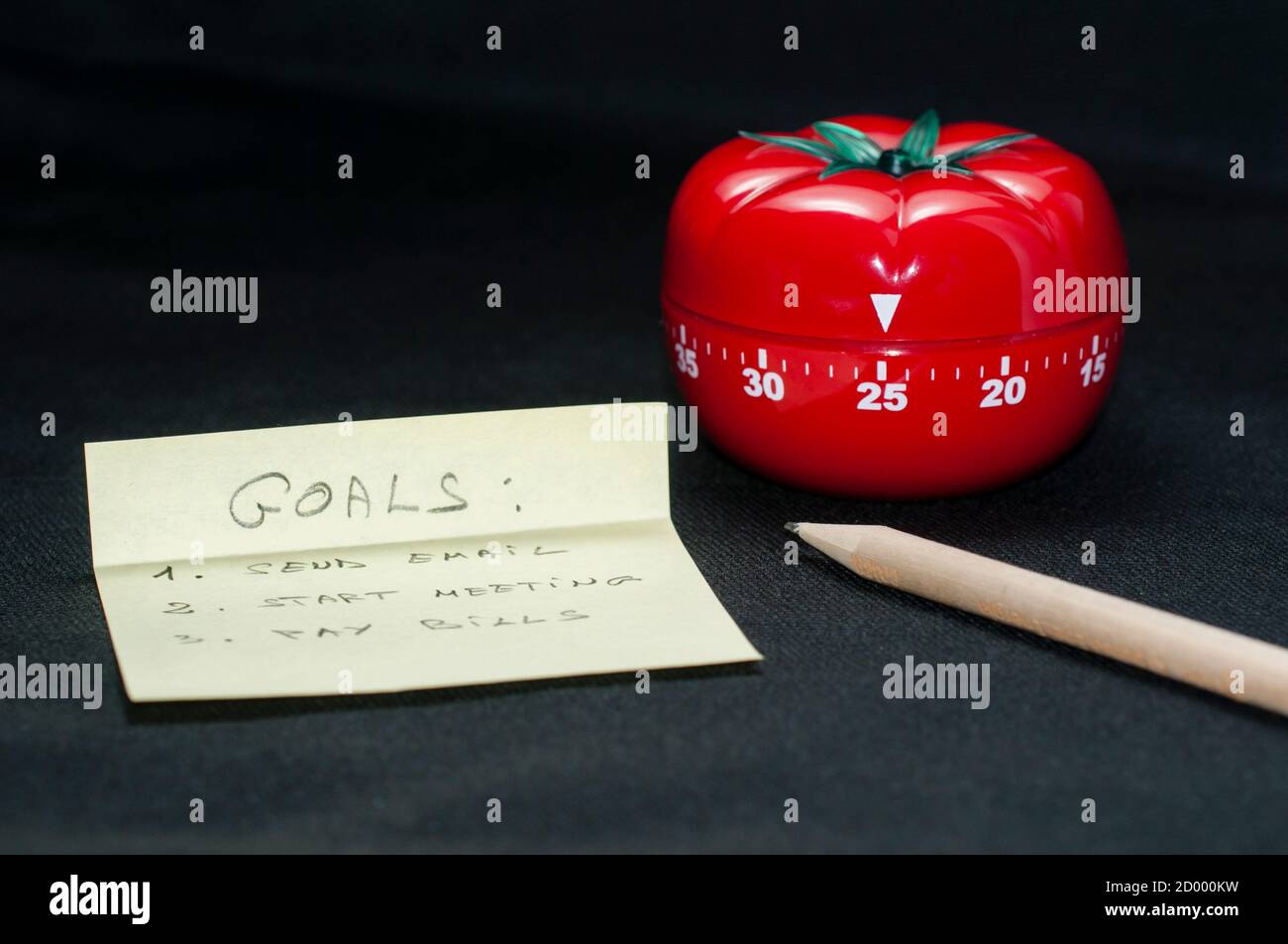 Timer da cucina a forma di pomodoro meccanico per cucinare, studiare e lavorare con matita e lista degli obiettivi. Foto Stock