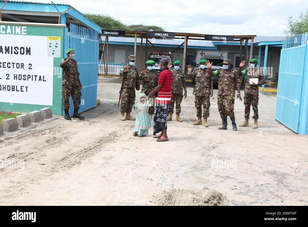 I soldati dell'AMISOM delle forze di difesa keniane a Dhobley, Somalia, salutano la bambina Naima Mohamed e suo padre dopo essere stata dimessa dall'ospedale AMISOM di secondo livello, dove ha ricevuto cure per gravi ustioni nell'arco di sette mesi. Foto Stock