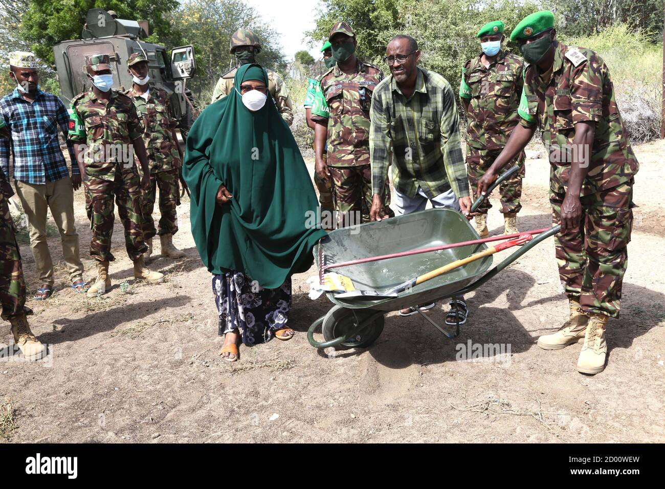 I soldati kenioti che prestano servizio nell’ambito della missione dell’Unione Africana in Somalia (AMISOM) hanno consegnato un assortimento di attrezzature costituite da carriole, rastrelli, picche e guanti, donate ai gruppi di donne a Dhobley, nella regione somala bassa di Juba, per contribuire a mantenere un ambiente pulito e sicuro il 25 giugno 2020. Foto Stock