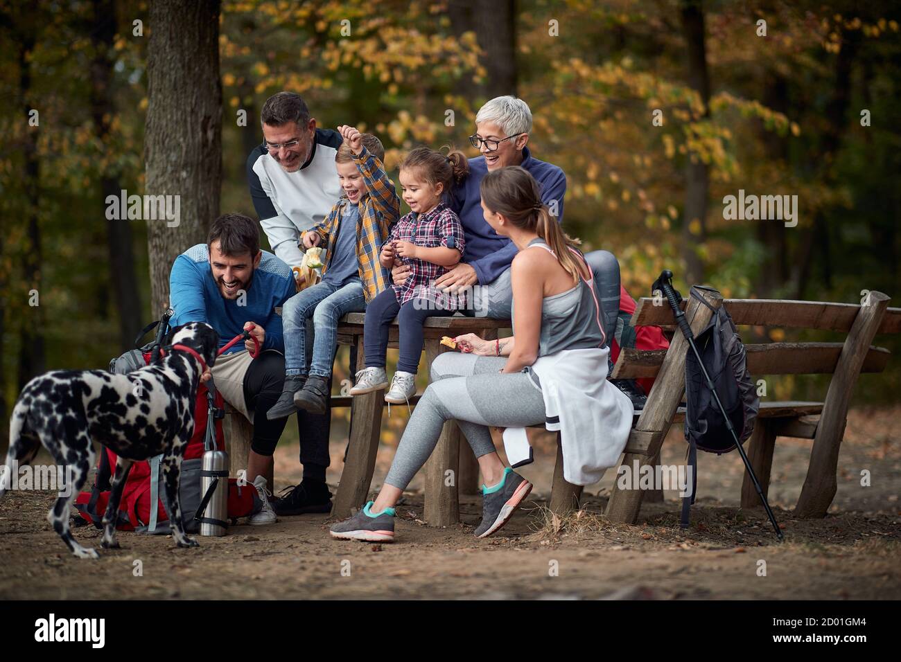 Famiglia felice con un cane che ha un picnic insieme nei boschi; escursioni in primavera o autunno nella natura; campeggio, viaggio, turismo, stile di vita, escursioni e peopl Foto Stock