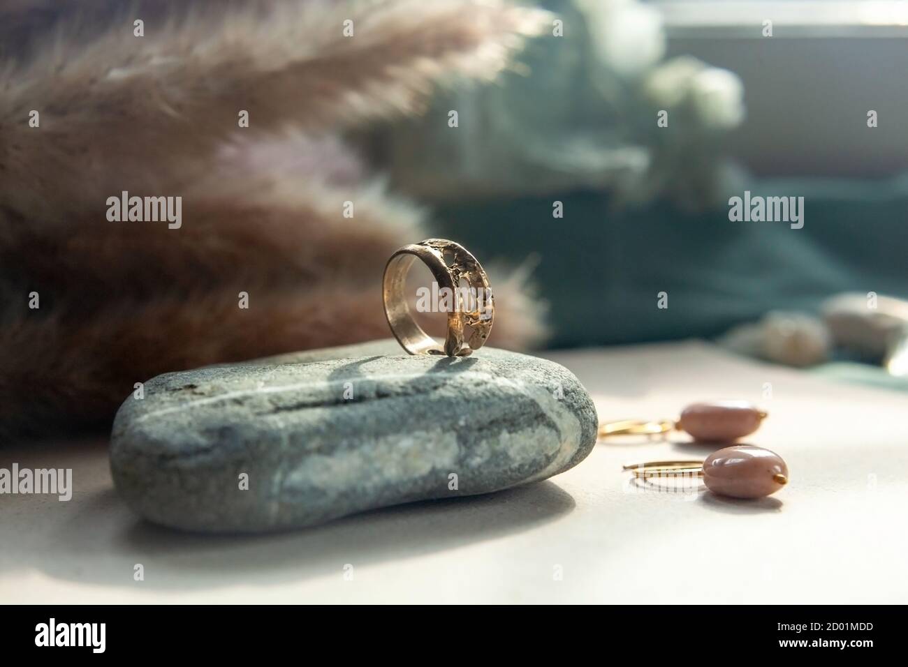 anello trendy in ottone pressofuso vintage. anello da donna di gioielli astratto disegno primo piano su una pietra grigia naturale con shadows Foto Stock