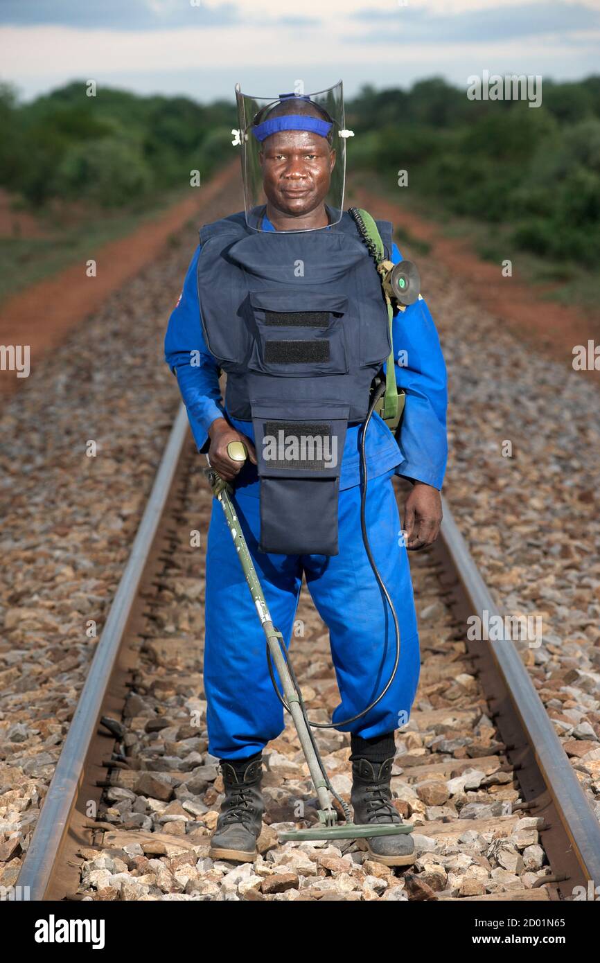 Ritratto di deminer Luis Vergonha con metal detector sulla linea ferroviaria di Chokwe nella provincia di Gaza, Mozambico. Foto Stock