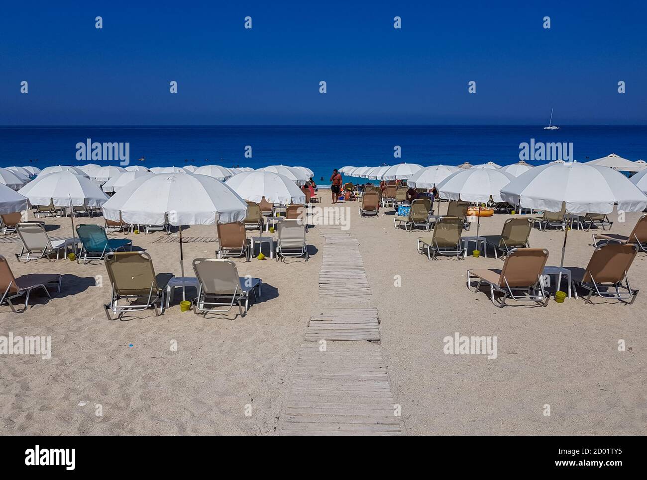 Turista godendo di una calda giornata estiva sulla spiaggia in Grecia. Foto Stock