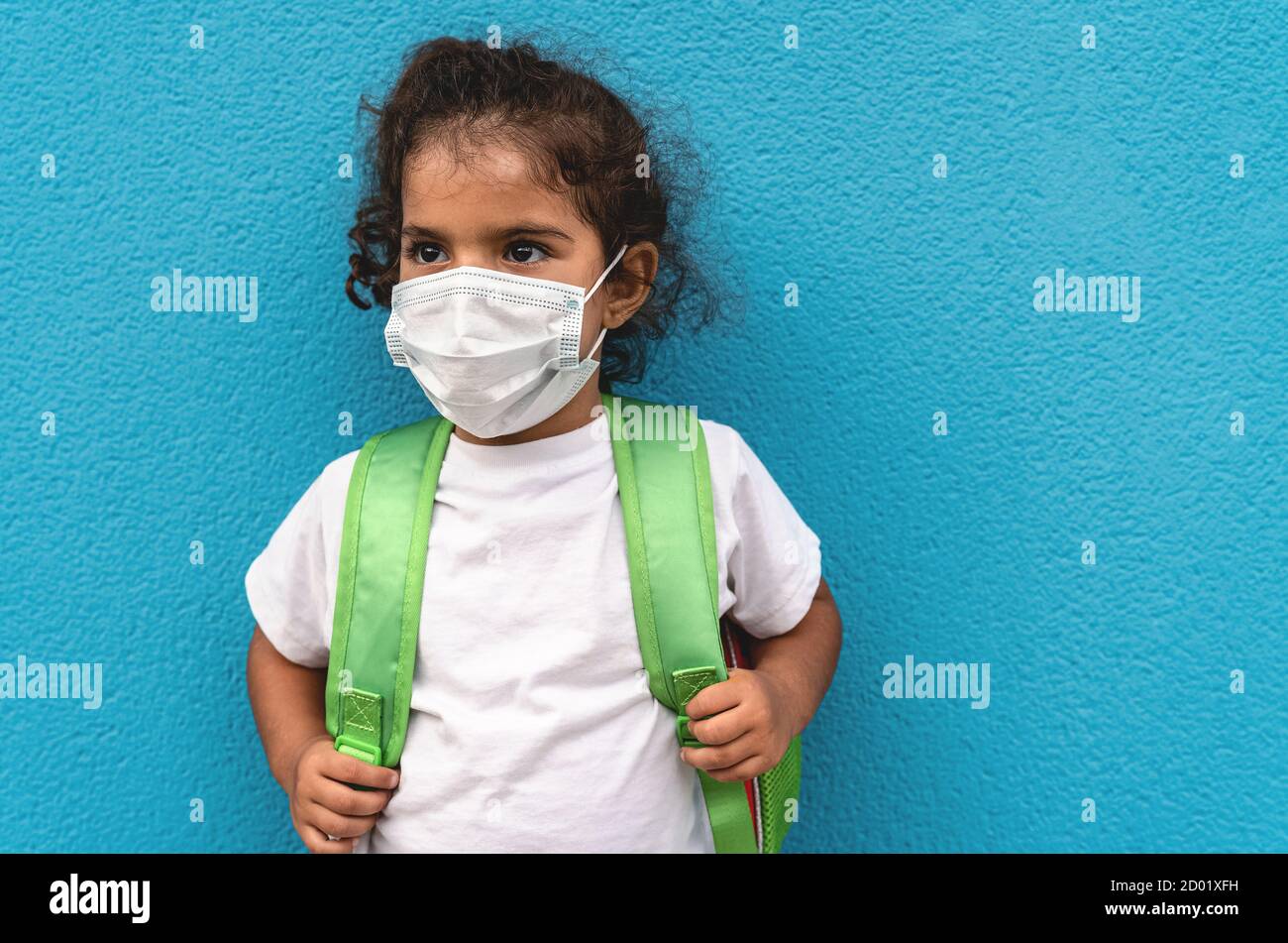 Bambino che indossa una maschera protettiva per il viso che torna a scuola durante pandemia del virus della corona - concetto di sanità e istruzione Foto Stock