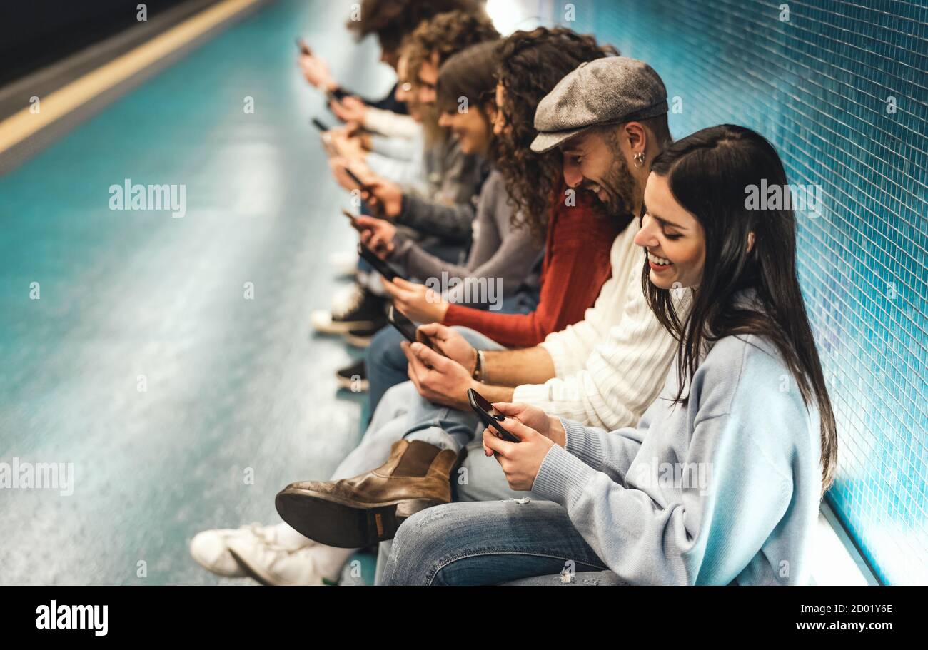 I giovani che usano lo smartphone mobile mentre si siedono in metropolitana in attesa formazione - millenario della gioventù dipendente dal concetto di nuova tecnologia Foto Stock
