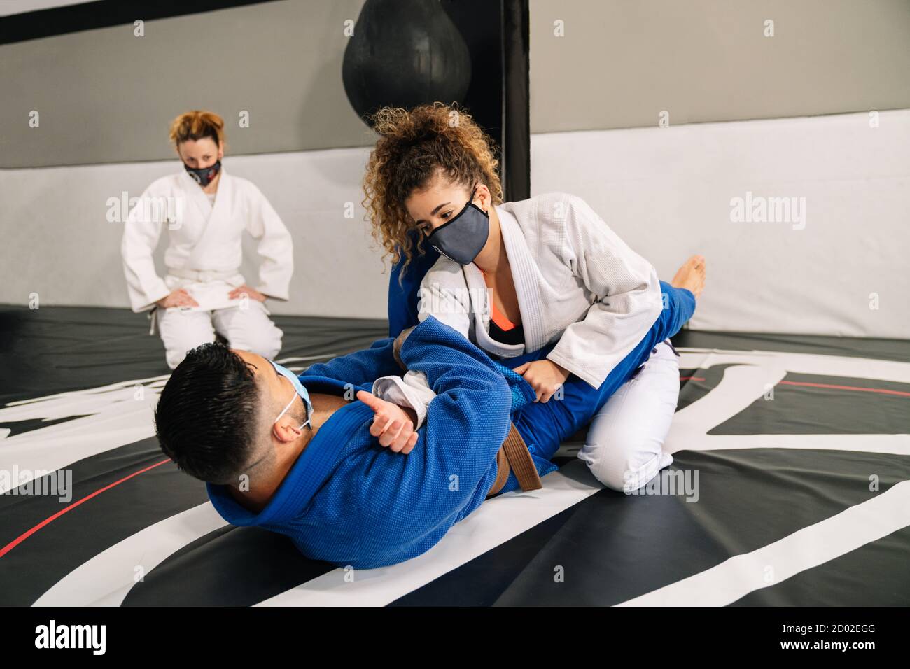 Uomo e donna che addestrano arti marziali e judo con kimonos sul tappetino  del piano della