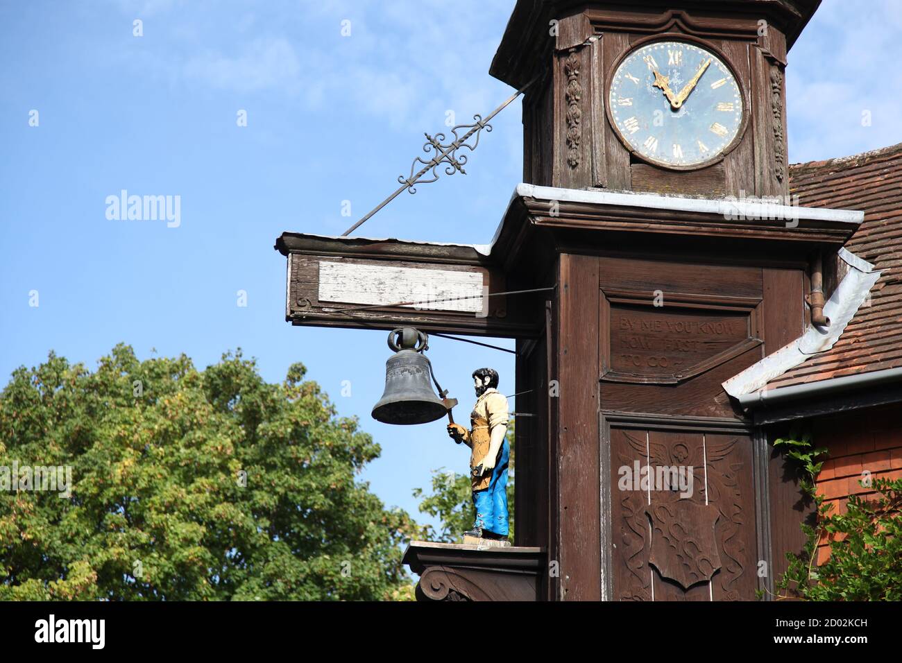 Abinger Hammer Clock sovrasta la strada principale e raffigura la figura di 'Jack il fabbro', in memoria del primo Lord Farrer di Abinger Hall Who Foto Stock