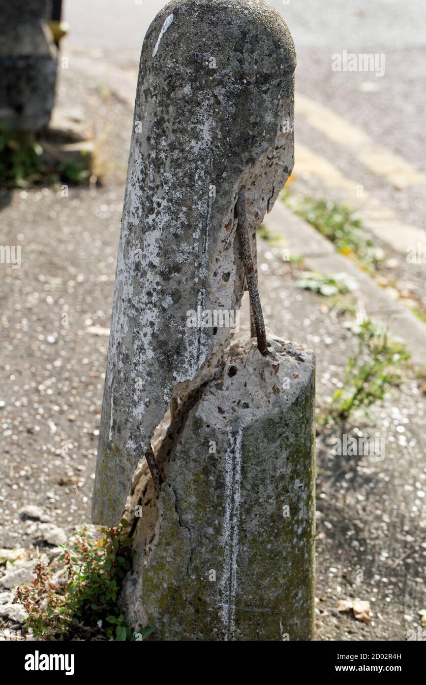Un bullard in cemento fratturato da vicino in formato ritratto Foto Stock