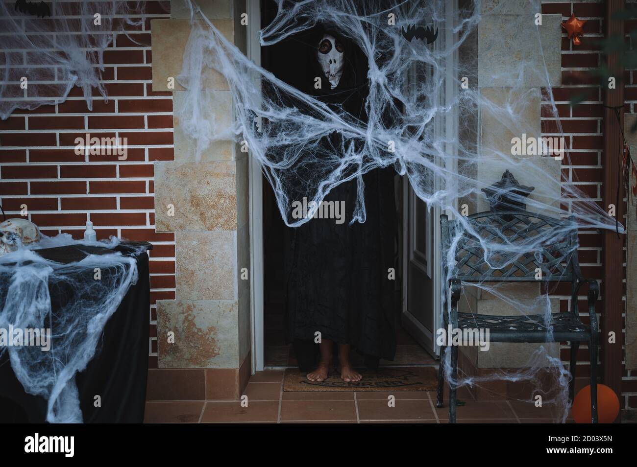 Persona in un costume horror per Halloween dietro un ragno web Foto Stock