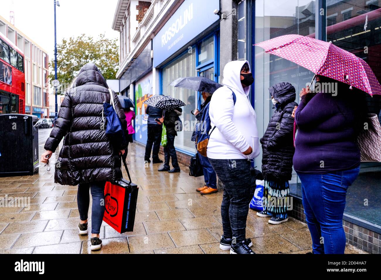 Londra UK, ottobre 02 2020, acquirenti anonimi o persone che riparano sotto gli ombrelloni durante Heavy Rain Foto Stock