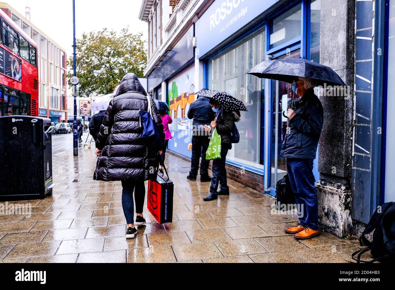 Londra UK, ottobre 02 2020, acquirenti anonimi o persone che riparano sotto gli ombrelloni durante Heavy Rain Foto Stock