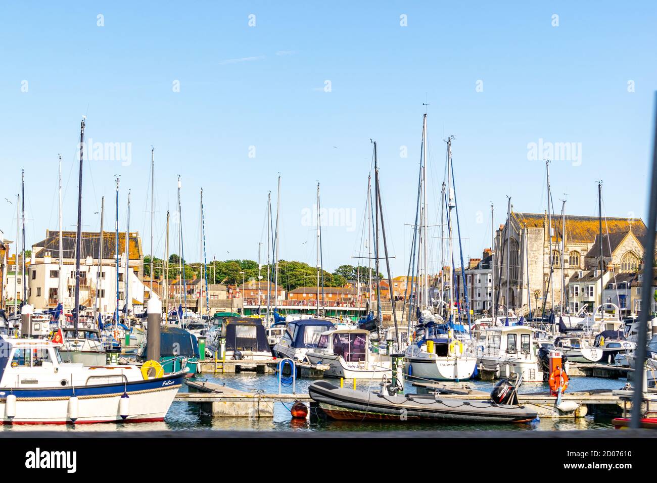 Weymouth, Regno Unito - 17 luglio 2020: Porto turistico di Weymouth con molte barche ormeggiate e centro commerciale sullo sfondo Foto Stock