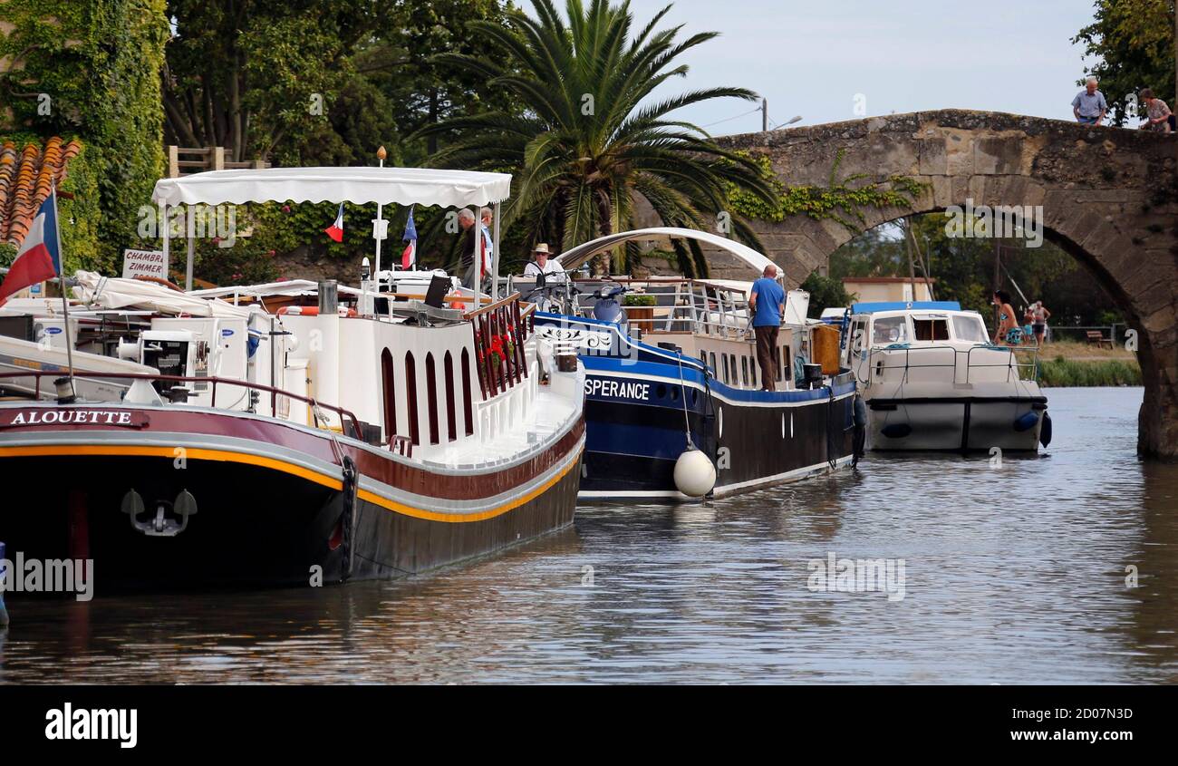 Barche fluviali di turisti sono ormeggiate nel porto di le Somail lungo il  Canal du Midi, Francia sud-occidentale, 12 agosto 2014, durante le vacanze  estive. Questa rete di 360 km di canali