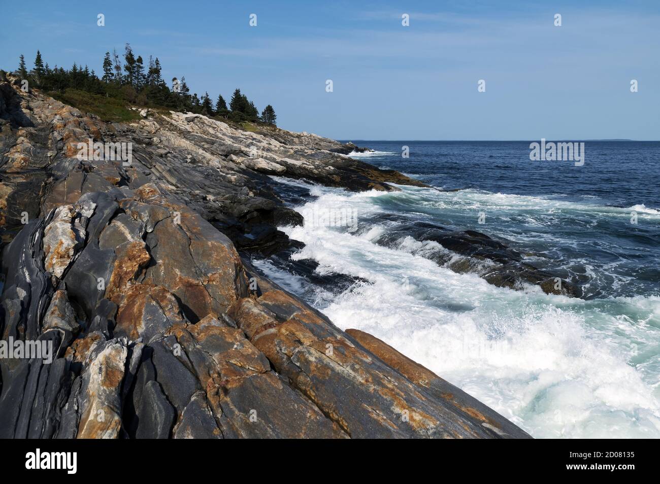Onde che si infrangono su formazioni rocciose metamorfiche uniche che si trovano lungo Pemaquid Point, a Bristol, intorno alla metà della costa del Maine. Foto Stock