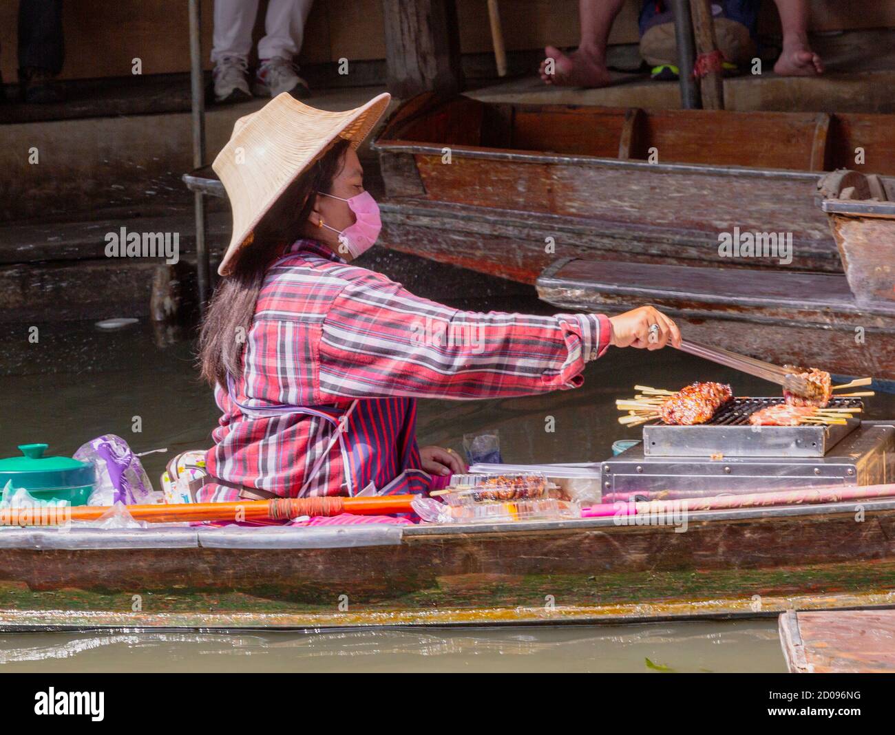 Bangkok, Tahiland - 2019-03-03 - Donne vendere il cibo da imbarcazioni presso il Mercato Galleggiante Foto Stock