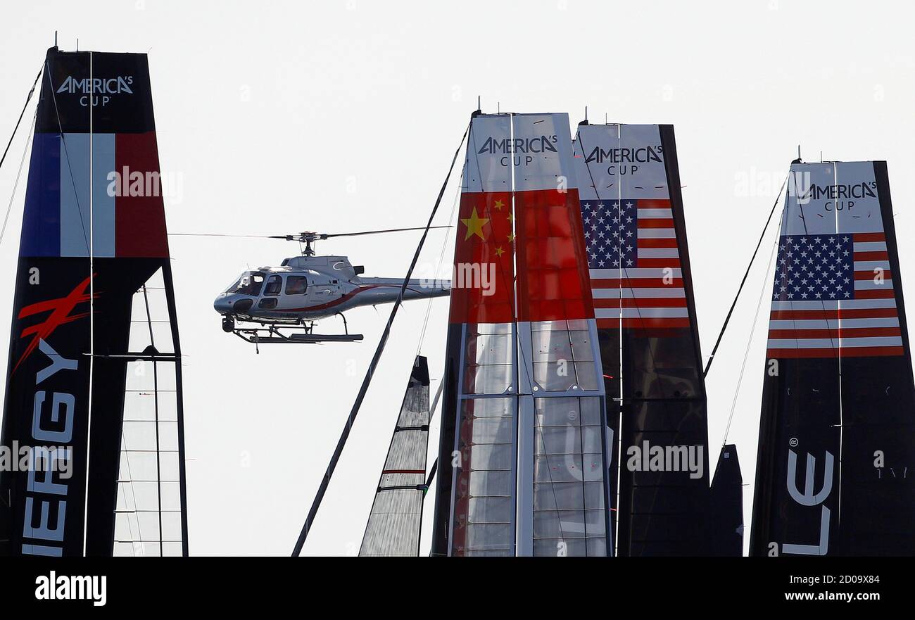 A helicopter flies over the competing multihulls during the America's Cup World Series regatta in Naples April 12, 2012 . REUTERS/Alessandro Bianchi (ITALY - Tags: SPORT YACHTING TRANSPORT) Foto Stock