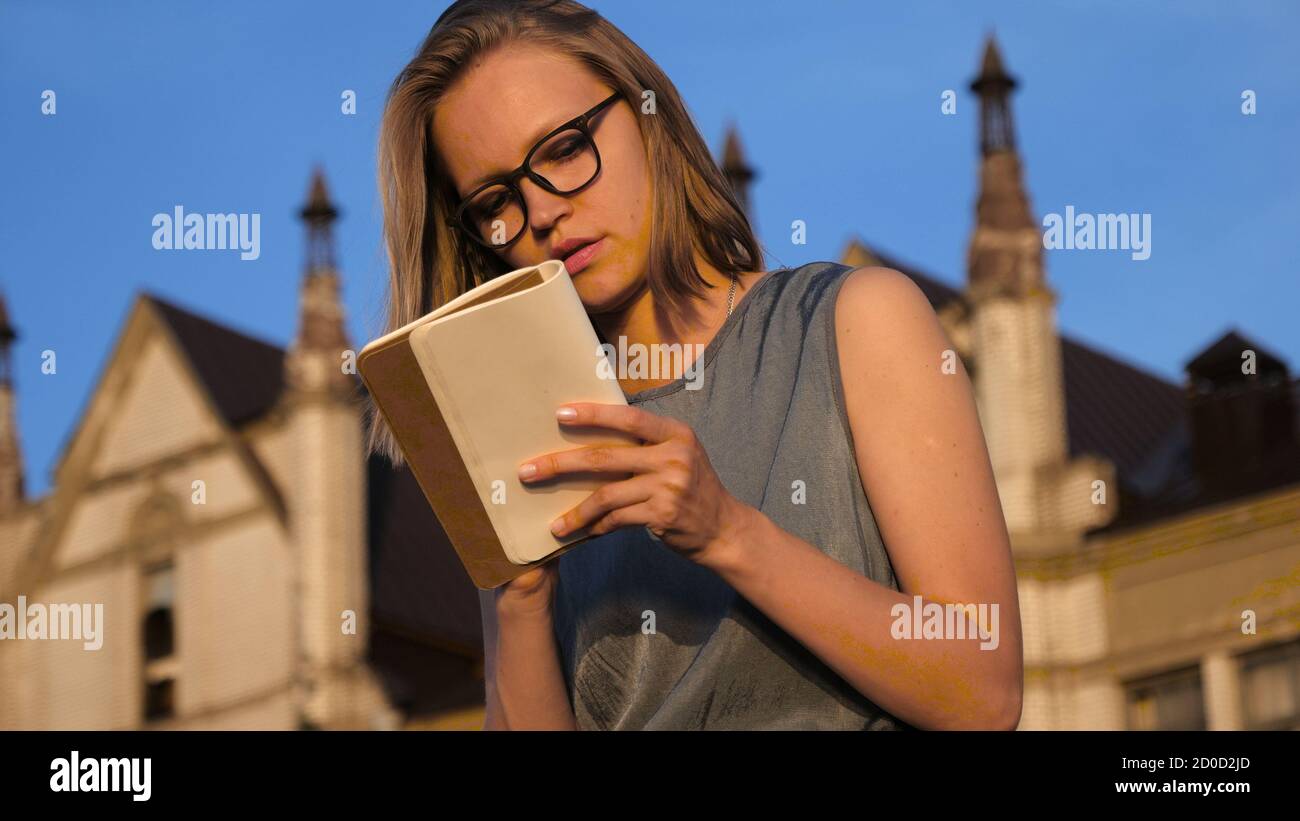 Hipster ragazza che scrive qualcosa nel suo notebook. Foto Stock