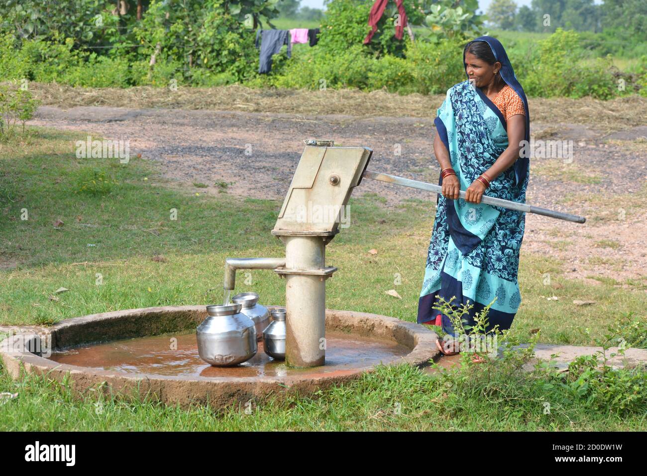 TIKAMGARH, MADHYA PRADESH, INDIA - 14 SETTEMBRE 2020: Donna indiana non identificata che usa la pompa a mano per l'acqua potabile. Foto Stock