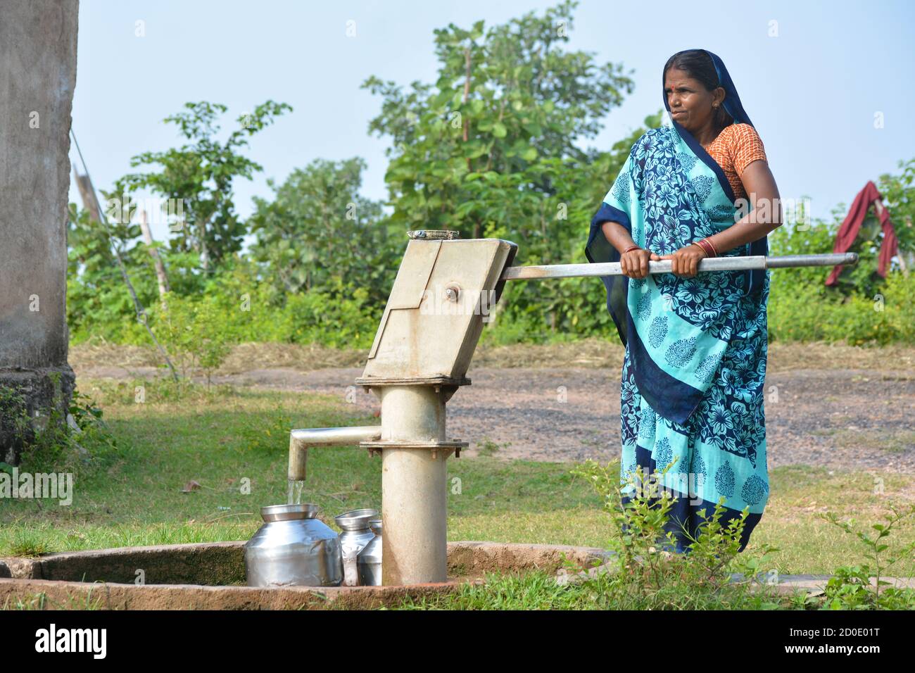 TIKAMGARH, MADHYA PRADESH, INDIA - 14 SETTEMBRE 2020: Donna indiana non identificata che usa la pompa a mano per l'acqua potabile. Foto Stock