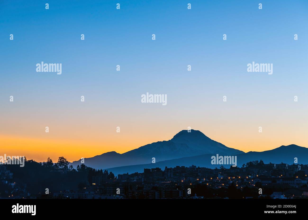 Quito città all'alba con la silhouette del vulcano Cayambe, Ecuador. Foto Stock