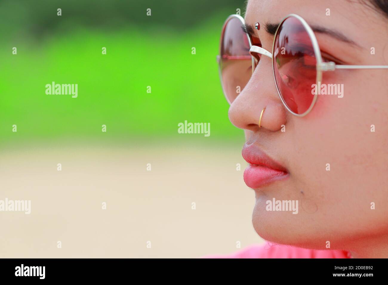 Macro profilo vista donna viso closeup splendide labbra rosa in naturale estate moda indossare occhiali da sole. Concetto di cura ( pelle , occhi ) parte superiore del corpo Foto Stock