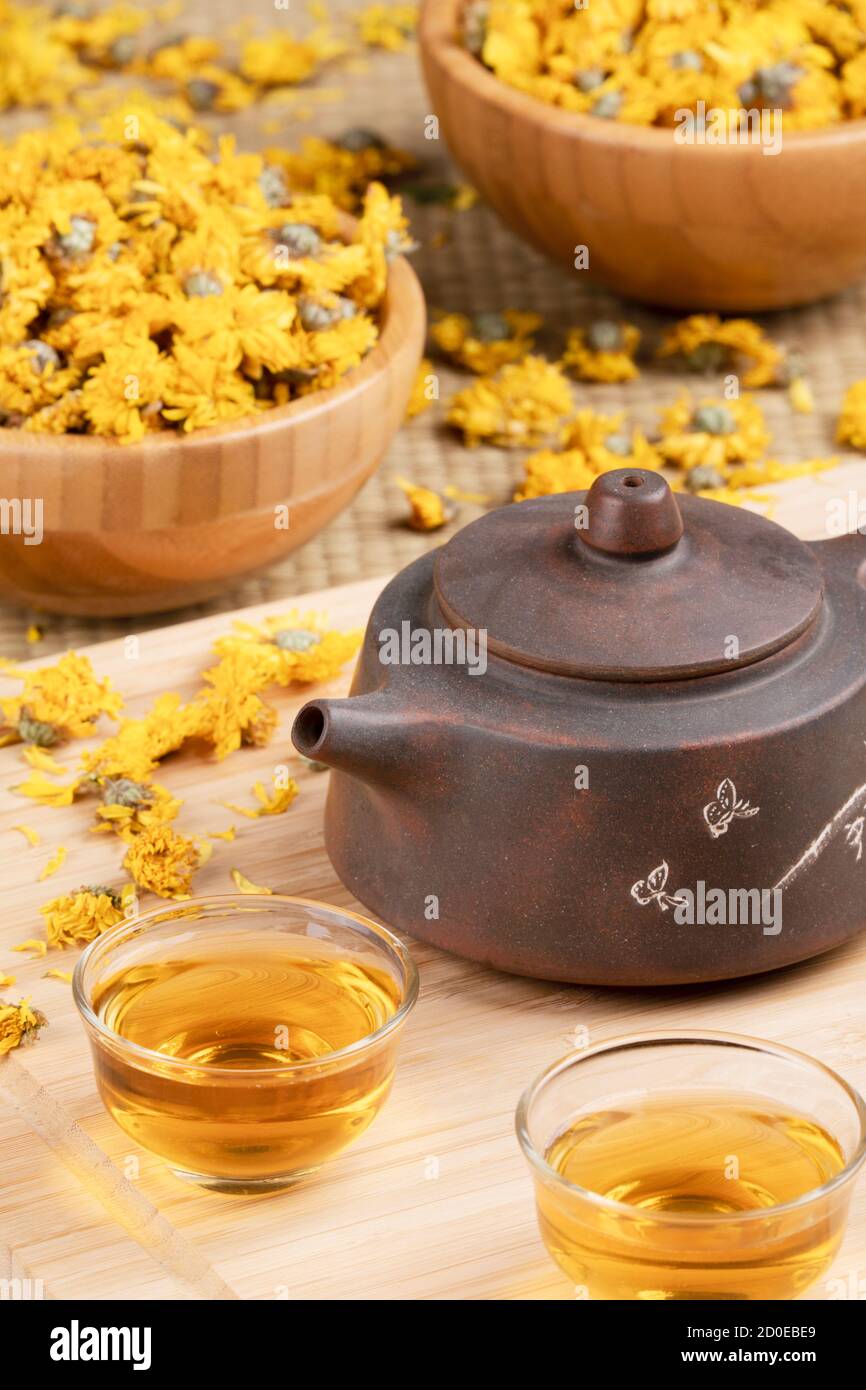 Primo piano di tradizionale tè cinese pentola e giallo Chamomile fiori isolati su sfondo di legno Foto Stock