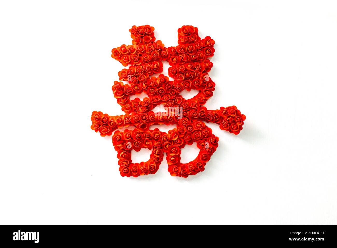 Un simbolo di 'doppia felicità' in caratteri cinesi fatti con rose rosse su sfondo bianco (traduzione : doppia felicità' Foto Stock