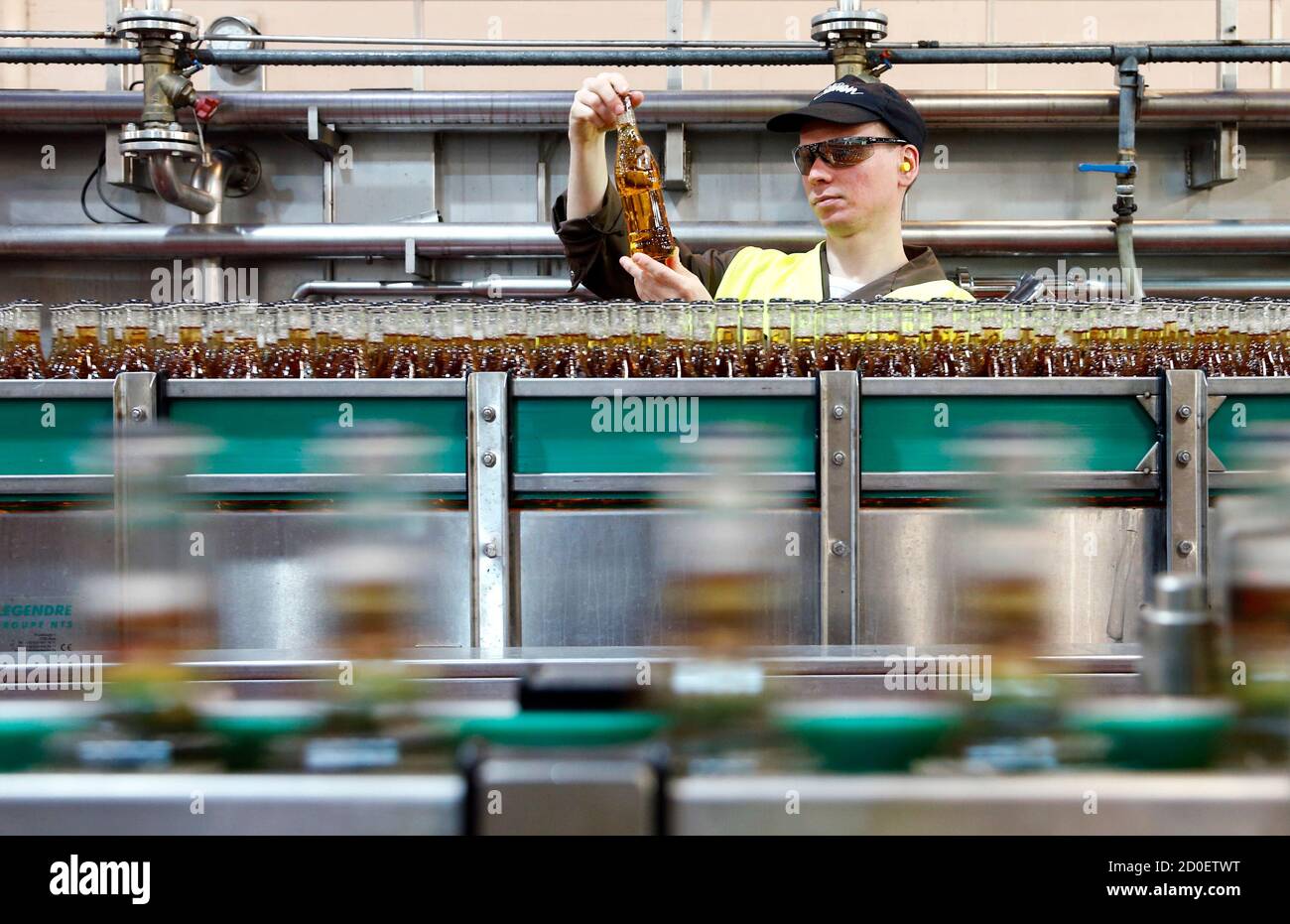 Un lavoratore detiene una bottiglia di Strongbow Gold sidro come si trova  accanto alla linea di produzione presso la fabbrica di birra Stassen ad  Aubel vicino Liegi 10 dicembre 2012. Il sidro,