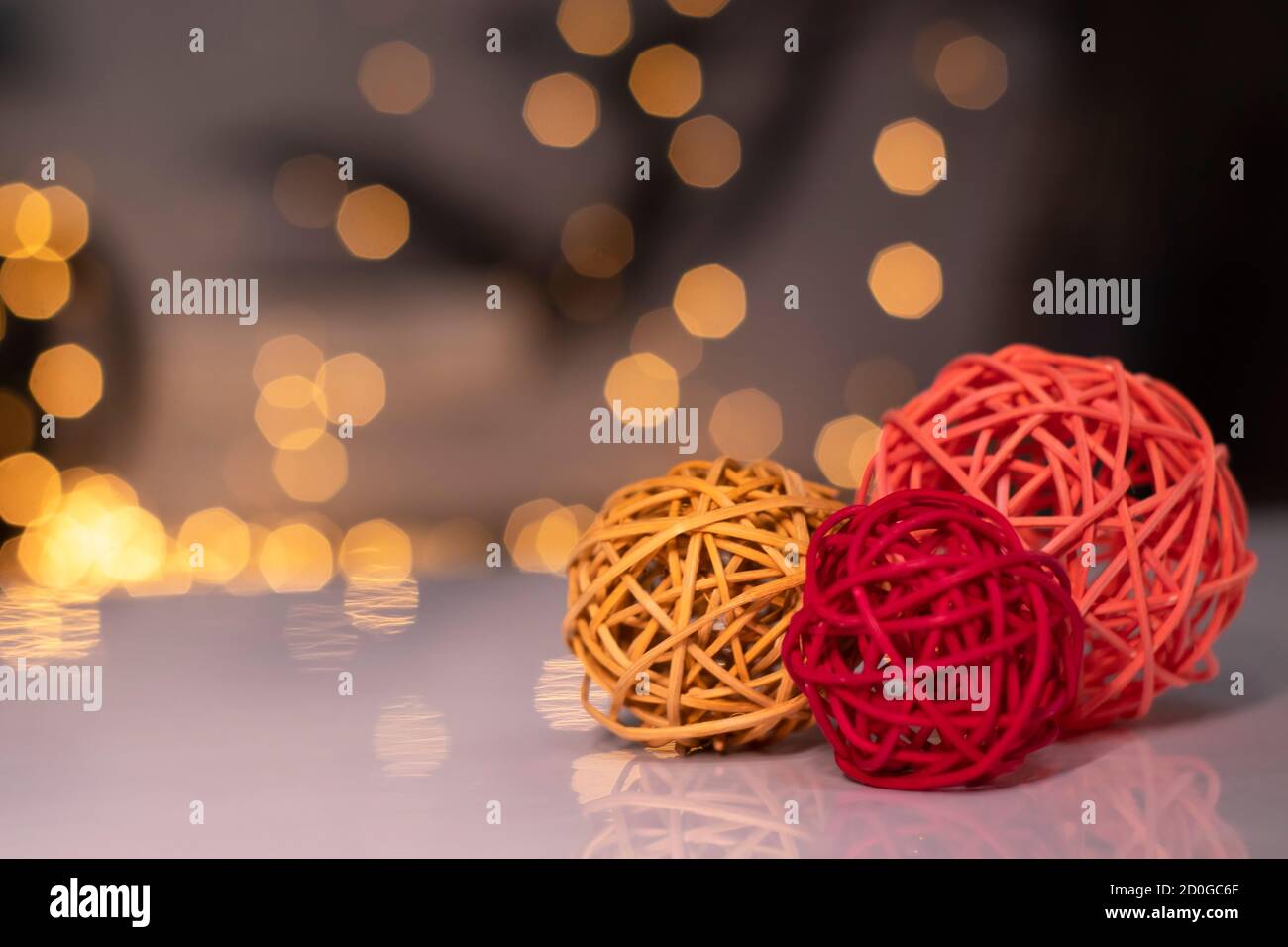 palline di vimini arancioni, rosse e rosa per la decorazione su sfondo di bokeh dorato. Foto Stock