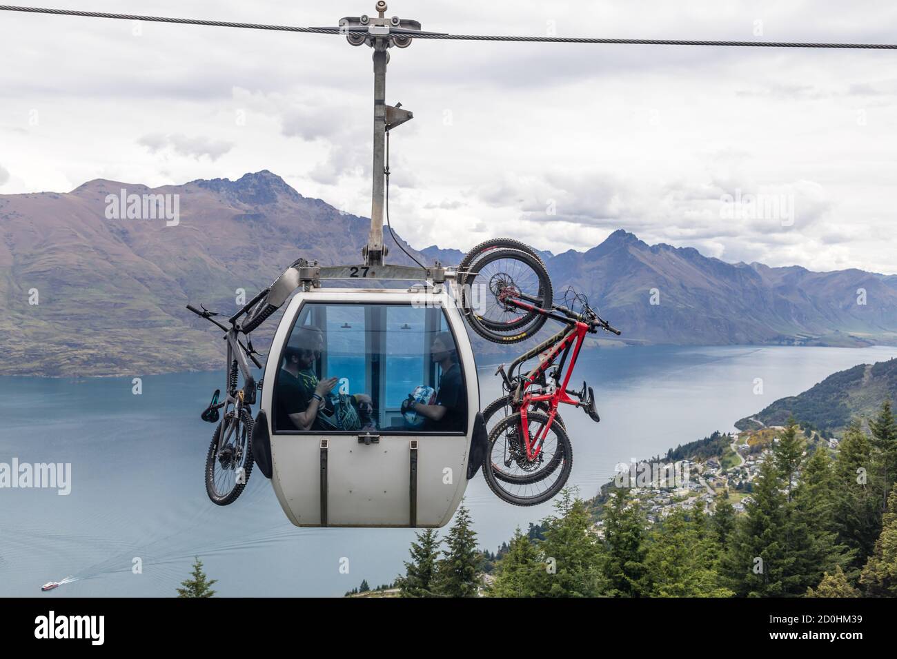 Queenstown, Nuova Zelanda: Trasporto in bicicletta con la Skyline Gondola. Sullo sfondo la vista panoramica del lago Wakatipu. Foto Stock