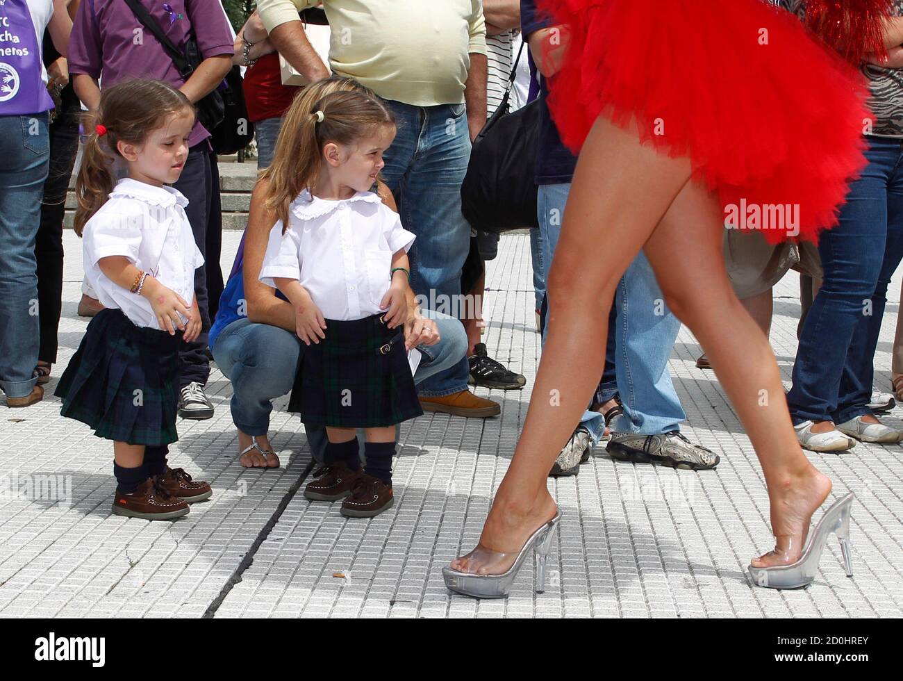 Un modello cammina accanto ai gemelli di otto anni Valentina e Maite che  soffrono di Acondrlasia a Buenos Aires 29 febbraio 2012. Gli argentini che  soffrono di malattie rare si sono riuniti