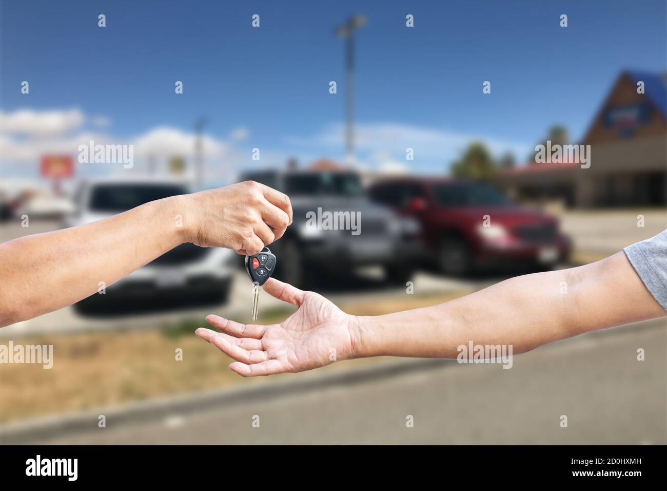 Closeup una mano dell'uomo sta trasportando una chiave dell'automobile alla mano di un altro uomo, uso per il concetto di industria di riparazione dell'automobile, assicurazione o commercio dell'automobile. Foto Stock