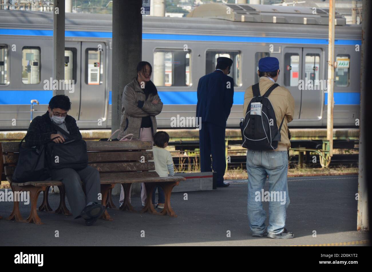 Pendolari in attesa sul binario alla stazione JR di Nagasaki Foto Stock