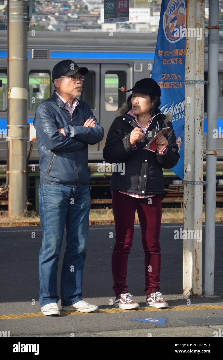 Pendolari in attesa sul binario alla stazione JR di Nagasaki Foto Stock