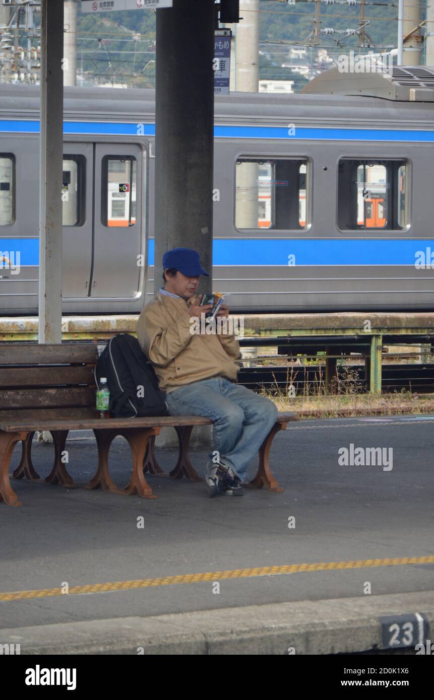Pendolari in attesa sul binario alla stazione JR di Nagasaki Foto Stock