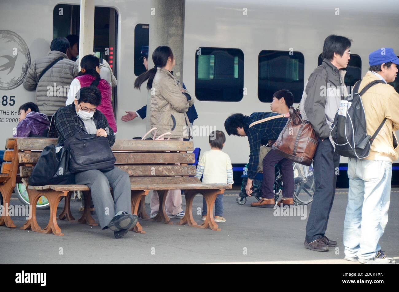 Pendolari in attesa sul binario alla stazione JR di Nagasaki Foto Stock