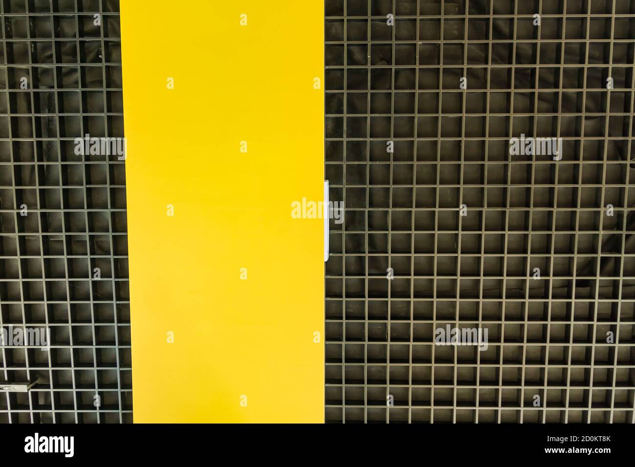 Vista dal basso del soffitto nero moderno con pannello giallo. Design degli interni. Sfondo Foto Stock
