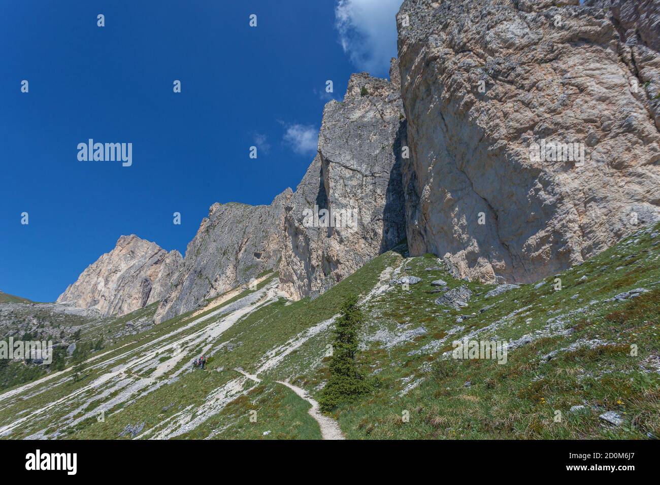 Persone irriconoscibili che camminano ai germogli dell'imponente parete dolomitica, Settsass, Dolomiti, Italia Foto Stock