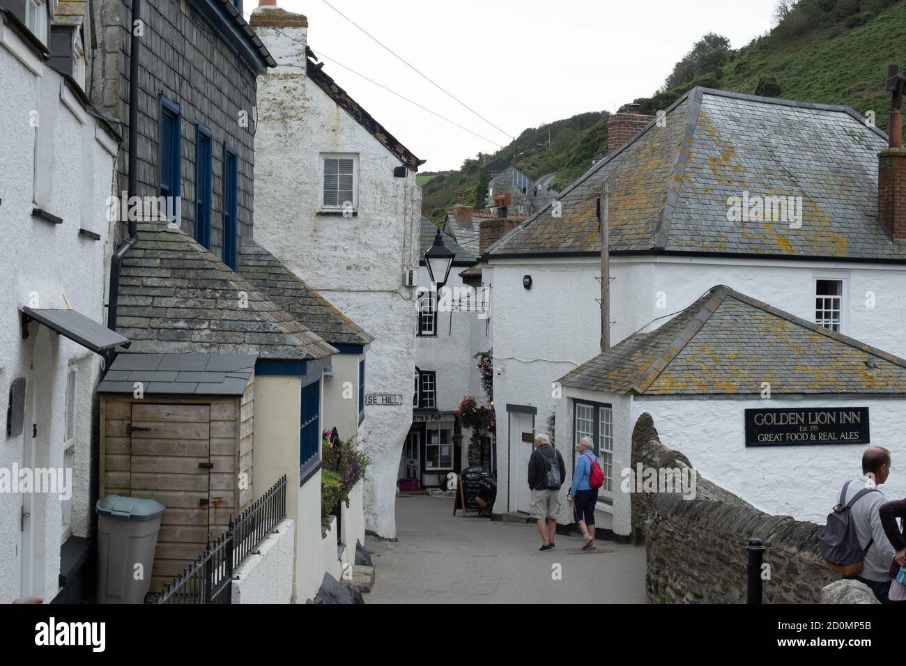 Narrow Street che conduce al centro di Port Isaac, con il Golden Lion Inn sulla destra Foto Stock