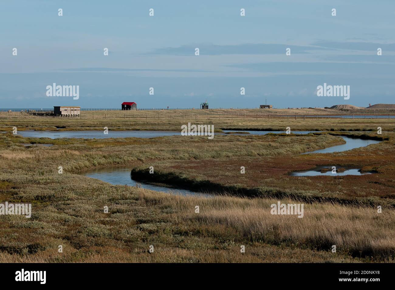 Una vista dei corsi d'acqua e degli edifici attraverso la Riserva Naturale di Rye Harbour, East Sussex Foto Stock