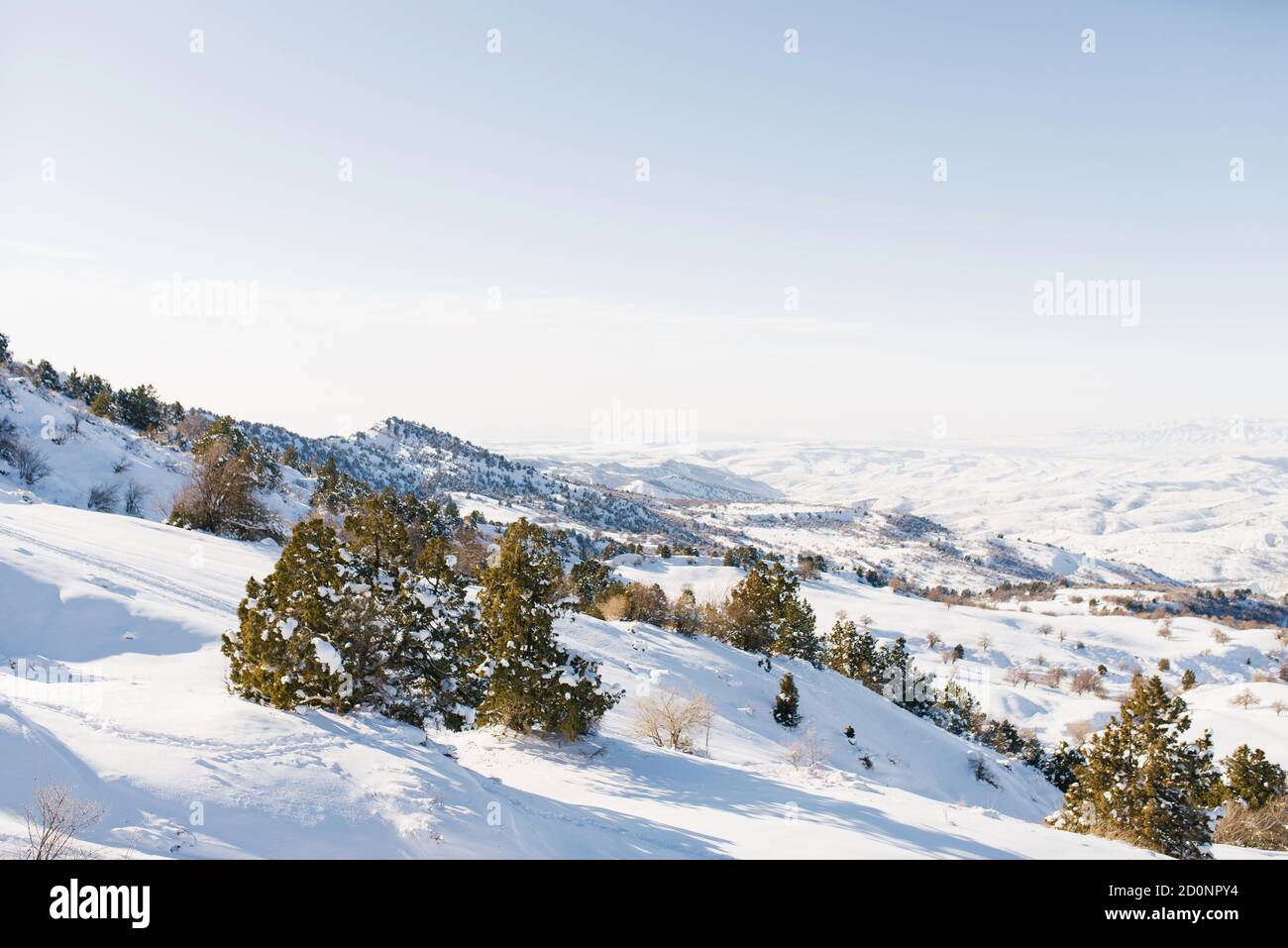 Piste innevate coperte di neve in tempo soleggiato. Paesaggio invernale tra le montagne della stazione sciistica di Beldersay Foto Stock