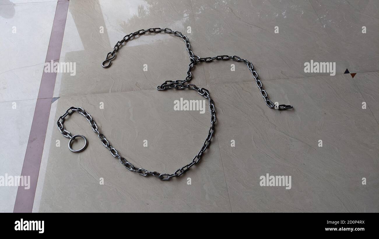 Primo piano del simbolo OM, realizzato con catena in ferro su marmo bianco. Segno della religione indù e della cultura indiana tradizionale. Foto Stock