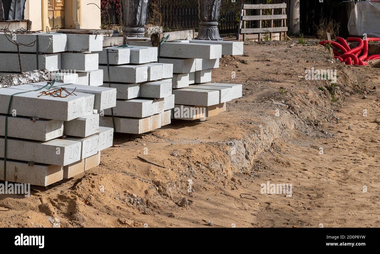 Piccolo cantiere. Blocchi di cemento giacciono sul terreno, pronti per la posa. Architettura paesaggistica, costruzione su piccola scala Foto Stock
