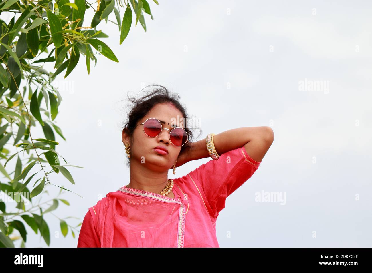 Modello femminile per adulti in posa in un bel vestito tradizionale e indossare nuovi occhiali da sole stile sopra gli occhi, moda estiva, promozione e indigena p Foto Stock Modello femminile per adulti in posa in un bel vestito tradizionale e indossare nuovi occhiali da sole stile sopra gli occhi, moda estiva, promozione e indigena p Foto Stock